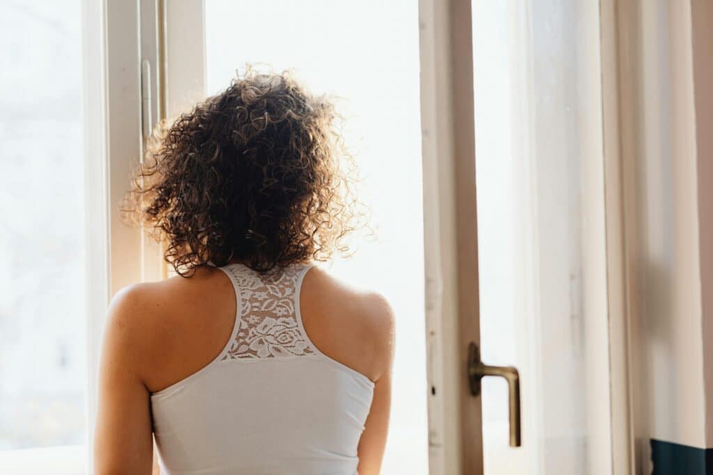 A woman standing by an open window