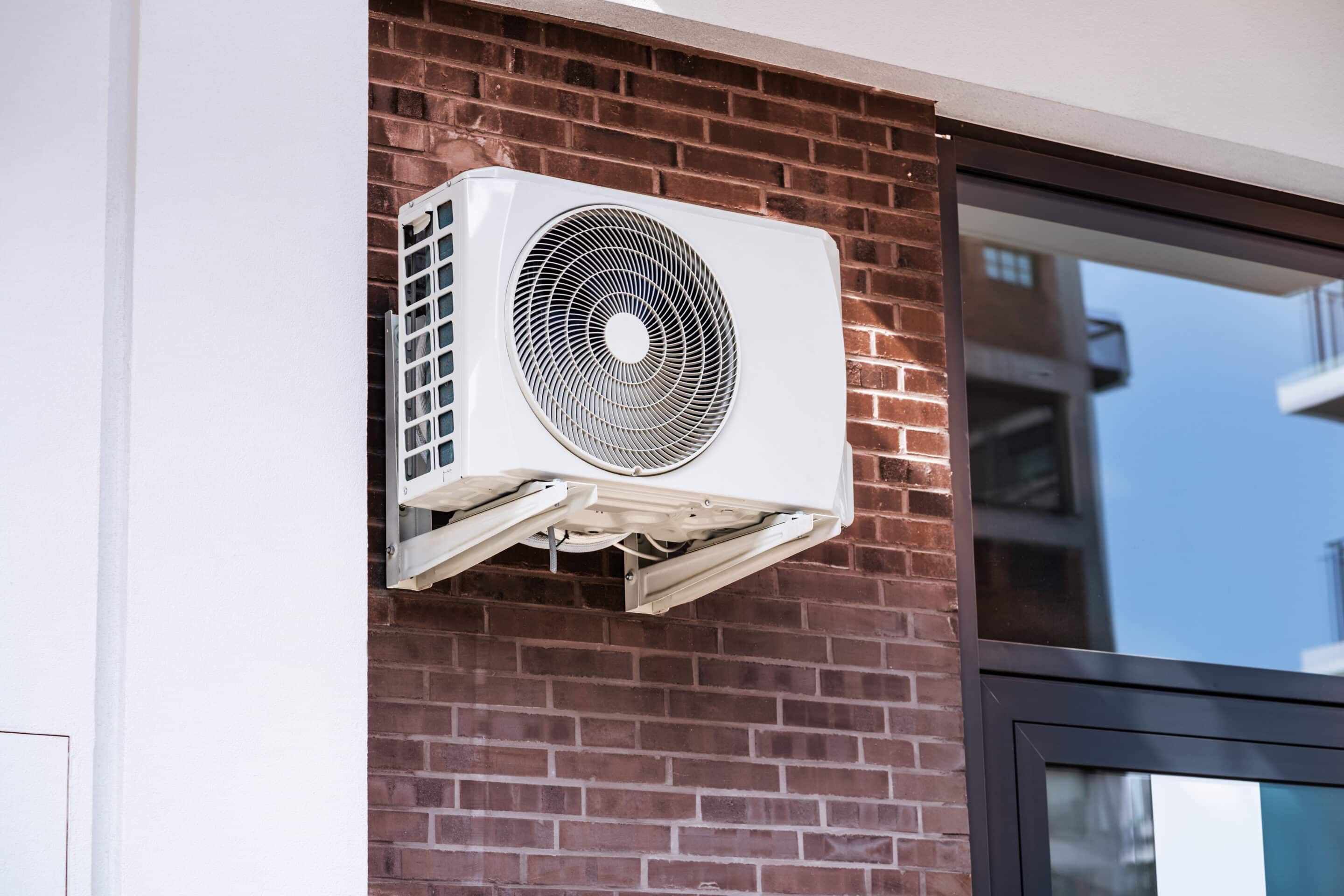 An air conditioner and heat pump attached to a wall.